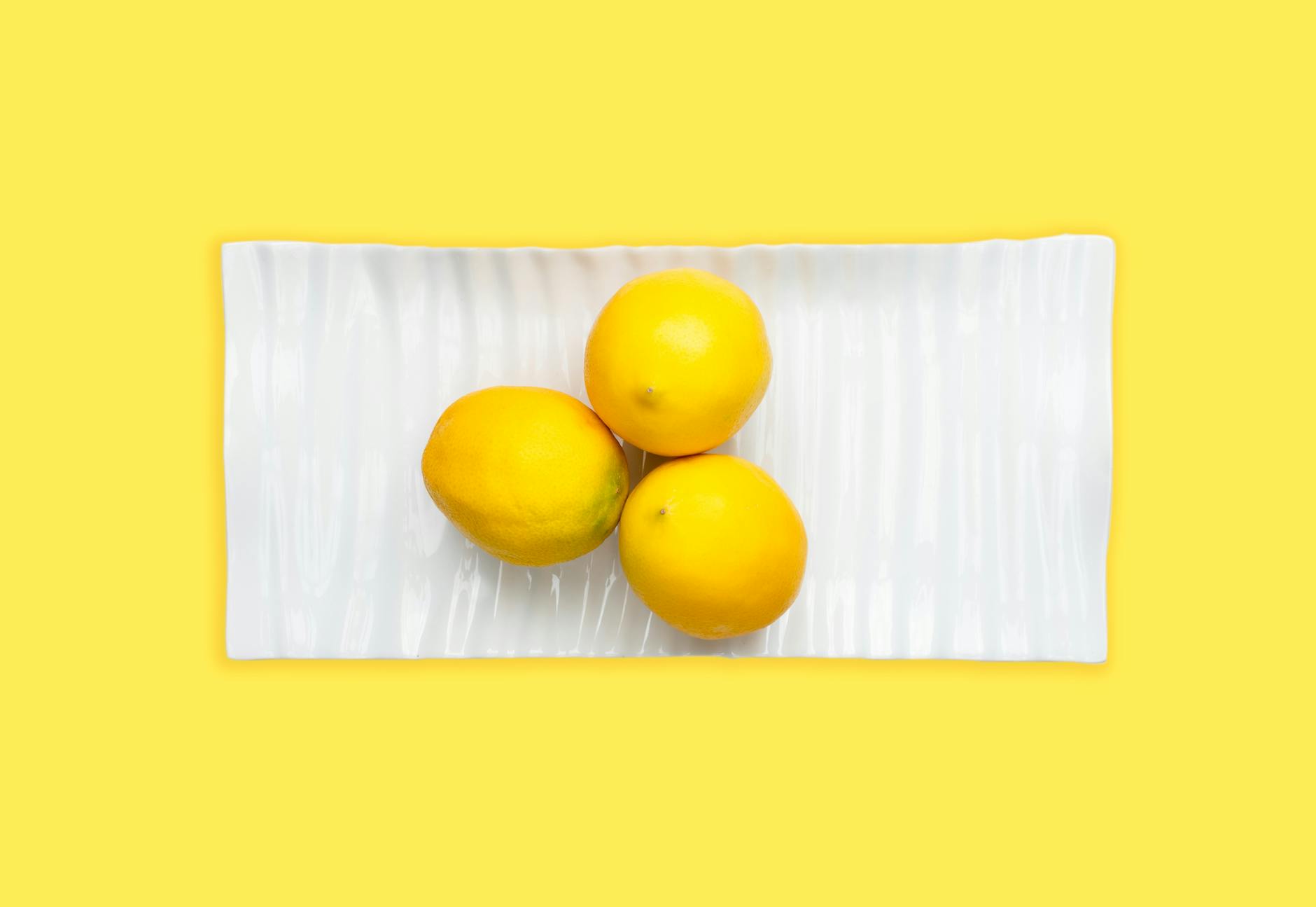 Fresh lemons arranged on white background, symbolizing the bright, gentle design of lemon vibrators