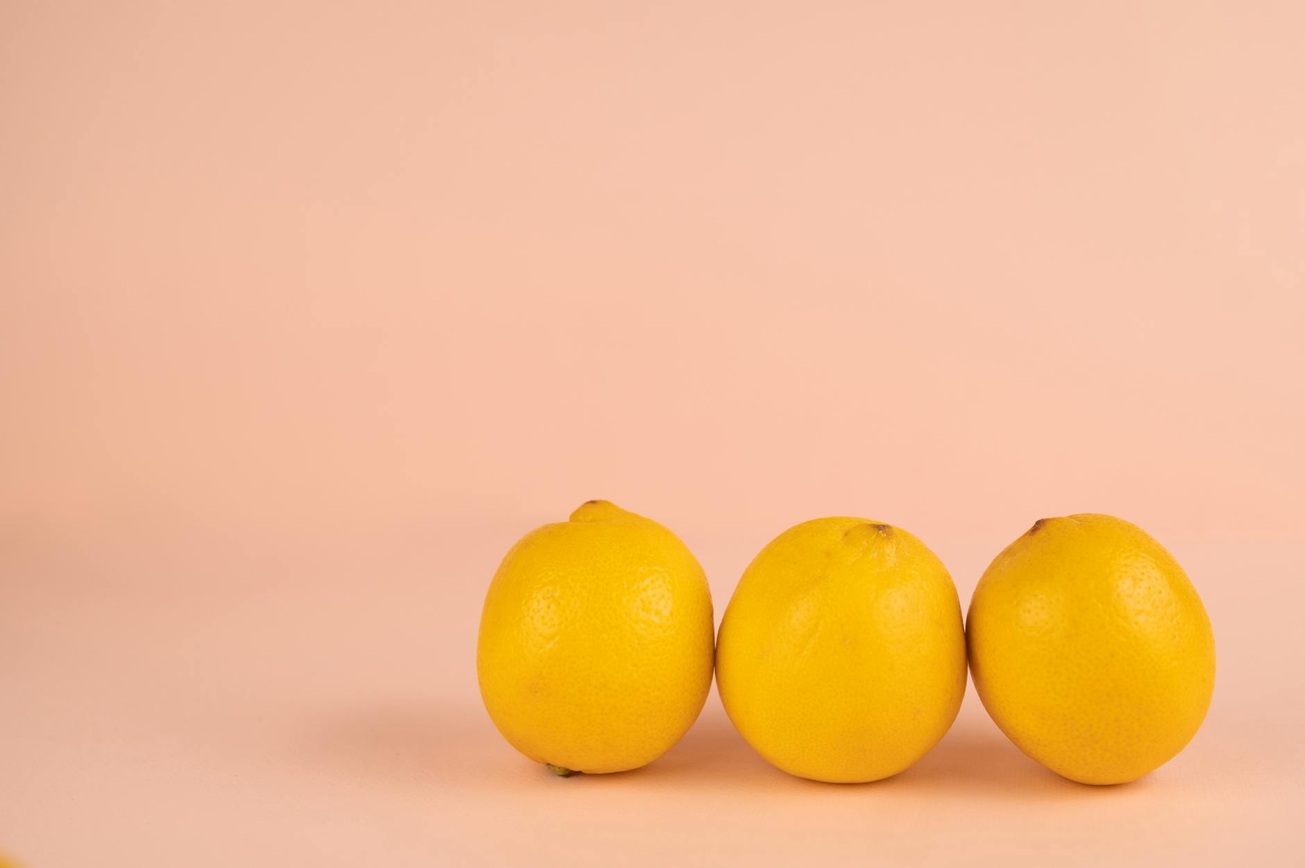 Bright ripe lemons arranged on a pastel background, symbolizing cyclical pleasure and freshness